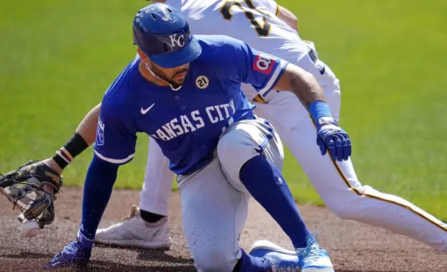 Kansas City Royals' Tommy Pham, front, slides safely into third with a triple as the relay throw gets past Pittsburgh Pirates third baseman Jared Triolo, back, during the third inning of a baseball game in Pittsburgh, Sunday, Sept. 15, 2024. (AP Photo/Gene J. Puskar)