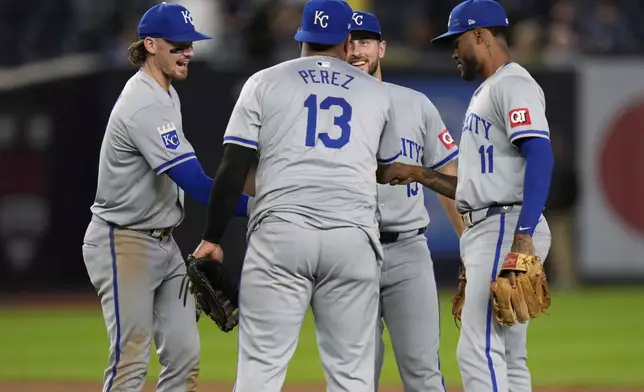 Kansas City Royals' Bobby Witt Jr., left, Salvador Perez (13), Paul DeJong, second from right, and Maikel Garcia (11) celebrate after a baseball game against the New York Yankees at Yankee Stadium, Tuesday, Sept. 10, 2024, in New York. (AP Photo/Seth Wenig)