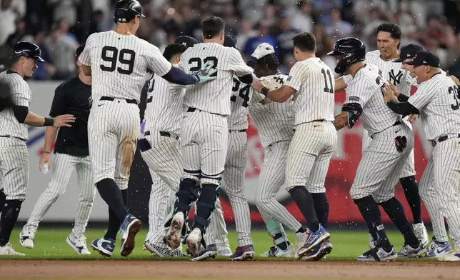 New York Yankees' celebrate after Jazz Chisholm Jr. hit a walk-off RBI single in the 11th inning after the a baseball game against the Kansas City Royals at Yankee Stadium Wednesday, Sept. 11, 2024, in New York. (AP Photo/Seth Wenig)