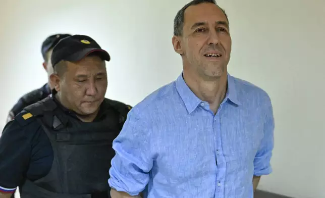 French citizen Laurent Vinatier, right, is escorted to a courtroom in the Zamoskvoretsky District Court in Moscow, Russia, Monday, Sept. 16, 2024. (AP Photo/Dmitry Serebryakov)