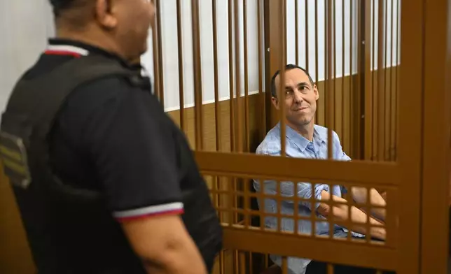 French citizen Laurent Vinatier, right, sits in a cage in a courtroom in the Zamoskvoretsky District Court in Moscow, Russia, Monday, Sept. 16, 2024. (AP Photo/Dmitry Serebryakov)