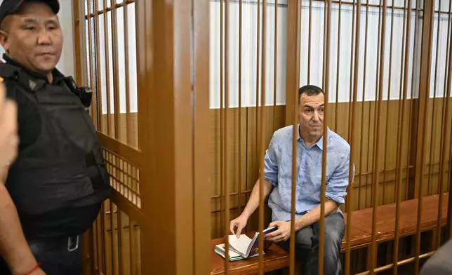 French citizen Laurent Vinatier, right, sits in a cage in a courtroom in the Zamoskvoretsky District Court in Moscow, Russia, Monday, Sept. 16, 2024. (AP Photo/Dmitry Serebryakov)