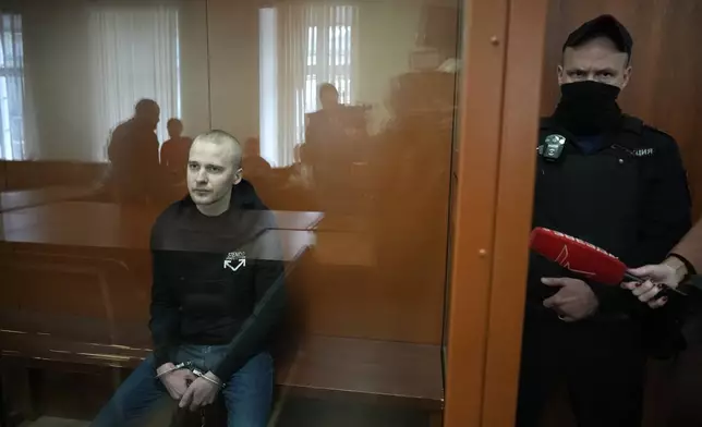 Alexander Permyakov, a Ukrainian national standing trial over a car bombing that injured well-known nationalist novelist and ardent Kremlin supporter Zakhar Prilepin, sits in a glass cage in a courtroom prior to a session in the Russian Military Court in Moscow, Russia, Monday, Sept. 30, 2024. (AP Photo/Alexander Zemlianichenko)