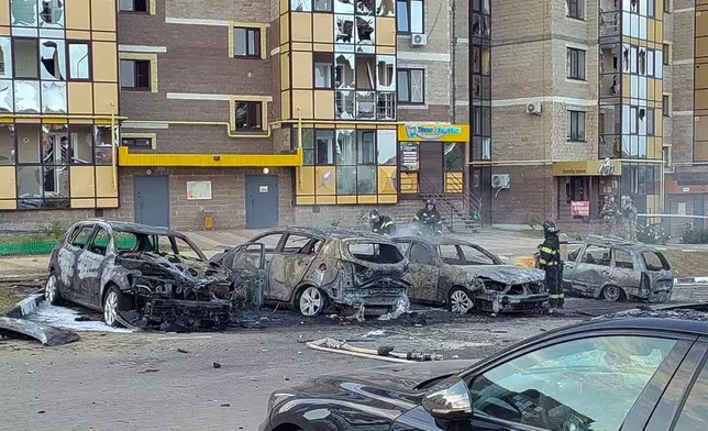 This photo released by Belgorod regional governor Vyacheslav Gladkov's Telegram channel on Monday, Sept. 2, 2024, Firefighters extinguish burning cars in the courtyard of an apartment building after a missile attack by the Armed Forces of Ukraine on the city of Belgorod, Russia. (Belgorod Region Governor Vyacheslav Gladkov Telegram channel via AP)