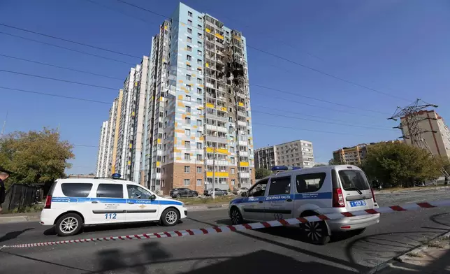 Police cars are parked at the site of the damaged multi-storey residential building following an alleged Ukrainian drone attack in Ramenskoye, outside Moscow, Moscow region, Russia, Tuesday, Sept. 10, 2024. (AP Photo)