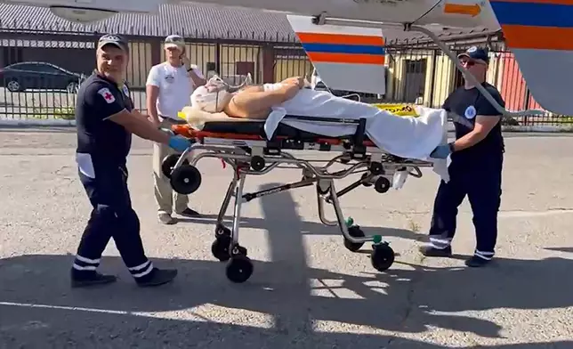 In this photo taken from video released by Moscow Region Governor Andrei Vorobyev official telegram channel, medical workers roll on a stretcher with a wounded man to a helicopter and transfer him to a Moscow's hospital, after an alleged Ukrainian drone attack on multi-storey residential building in Ramenskoye, outside Moscow, Moscow region, Russia, on Tuesday, Sept. 10, 2024. (Moscow Region Governor Andrei Vorobyev official telegram channel via AP)