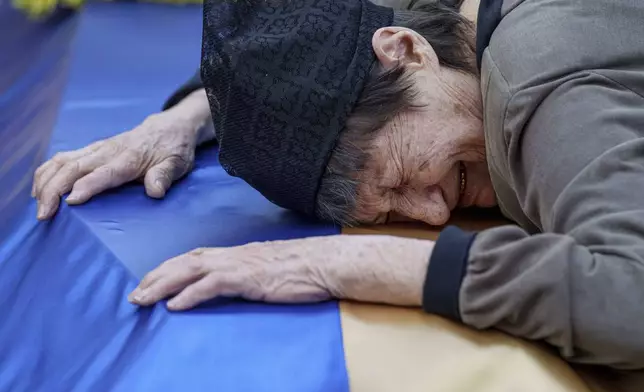 A mother cries near the coffin of her son killed in a Russian rocket attack at a Ukrainian military academy, during his funeral ceremony in Poltava, Ukraine, Saturday Sept. 7, 2024. (AP Photo/Evgeniy Maloletka)