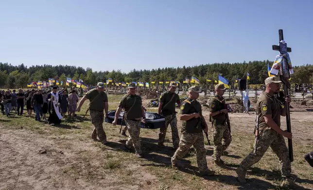 Ukrainian servicemen carry the coffin of their comrade Serhiy Dondiuk, killed in a Russian rocket attack at a Ukrainian military academy, during the funeral ceremony in Poltava, Ukraine, Saturday Sept. 7, 2024. (AP Photo/Evgeniy Maloletka)