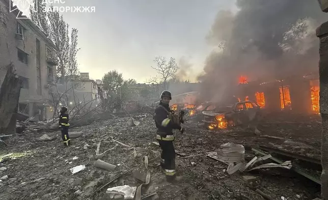 In this photo provided by the Ukrainian Emergency Service, firefighters put out the fire after Russia attacked the city with guided bombs overnight in Zaporizhzhia, Ukraine, Sunday, Sept. 29, 2024. (Ukrainian Emergency Service via AP)