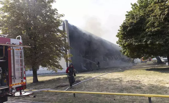 Rescue workers extinguish a fire at a sports facility destroyed after Russian attack in Kharkiv, Ukraine, Sunday, Sept. 1 2024. (AP Photo/Yevhen Titov)