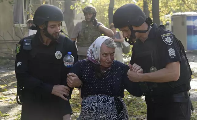 An elderly woman is assisted after a Russian aerial bomb struck a multi-story residential building in Kharkiv, Ukraine, Sunday Sept. 15, 2024. (AP Photo/Andrii Marienko)