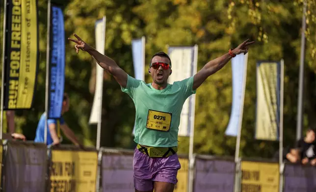 A man cheers as he participates in a charity run to raise awareness on Ukrainian prisoners of war held by Russia, in Kyiv, Ukraine, Saturday, Sept. 14, 2024. (AP Photo/Evgeniy Maloletka)