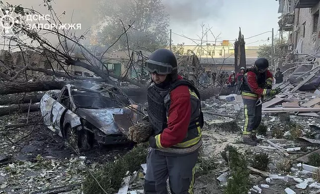 In this photo provided by the Ukrainian Emergency Service, emergency workers clear the rubble after Russia attacked the city with guided bombs overnight in Zaporizhzhia, Ukraine, Sunday, Sept. 29, 2024. (Ukrainian Emergency Service via AP)