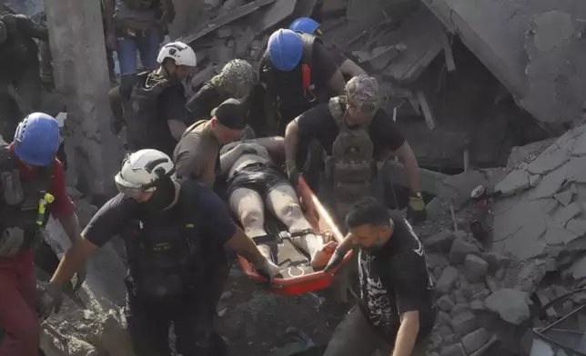 Rescuers carry a wounded man after Russian missile attack on the city palace of sports in Kharkiv, Ukraine, Sunday, Sept. 1, 2024. Over 40 civilians were injured in Sunday's missile attack. (AP Photo/Andrii Marienko)