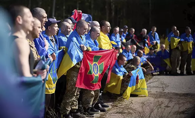 Ukrainians pose for a photo after being released in a prisoner exchange at an undisclosed location in Ukraine, Saturday Sept. 14, 2024. (Ukrainian Presidential Press Office via AP)