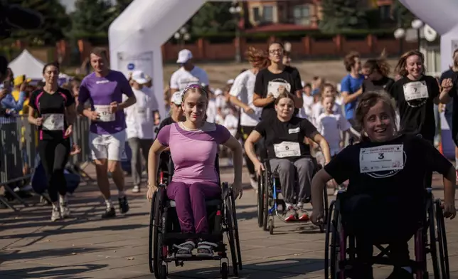 Women on wheelchairs participate in a charity run to raise awareness for people with disabilities in Kyiv, Ukraine, Saturday, Sept. 14, 2024. (AP Photo/Evgeniy Maloletka)