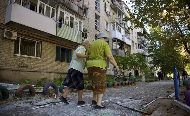 In this photo provided by the Dnipropetrovsk Military Administration on Friday, Sept. 6, 2024, local women walks near residential building which was damaged by a Russian strike in Pavlohrad, Ukraine. (Dnipropetrovsk Military Administration via AP)