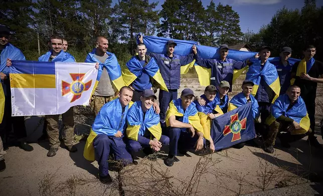 Ukrainians pose for a photo after being released in a prisoner exchange at an undisclosed location in Ukraine, Saturday Sept. 14, 2024. (Ukrainian Presidential Press Office via AP)