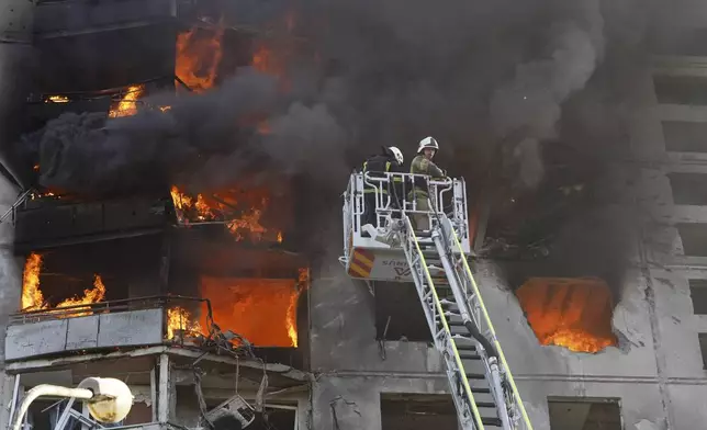 Firefighters tackle a blaze after a Russian aerial bomb struck a multi-story residential building in Kharkiv, Ukraine, Sunday Sept. 15, 2024. (AP Photo/Andrii Marienko)