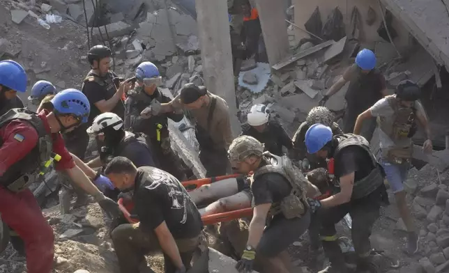 Rescuers carry a wounded man after Russian missile attack on the city palace of sports in Kharkiv, Ukraine, Sunday, Sept. 1, 2024. Over 40 civilians were injured in Sunday missile attack. (AP Photo/Andrii Marienko)