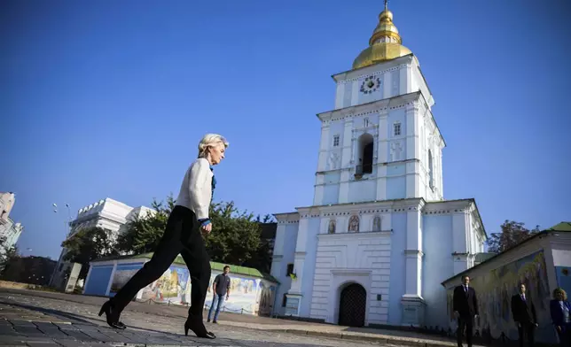 President of the European Commission Ursula von der Leyen, left, walks past St. Michael's Monastery on her way to visit a memorial wall commemorating the fallen Ukrainian soldiers in the war with Russia, in Kyiv, Ukraine, Friday, Sept. 20, 2024. (Christoph Soeder, Pool via AP)