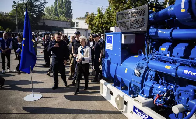 European Commission President Ursula von der Leyen, center, inspects a generator with head of State Emergency Service of Ukraine (SESU)Andriy Danyk during a visit to the headquarters of the State Emergency Service (SESU), in Kyiv, Ukraine, Friday, Sept. 20, 2024. (Christoph Soeder, Pool via AP)