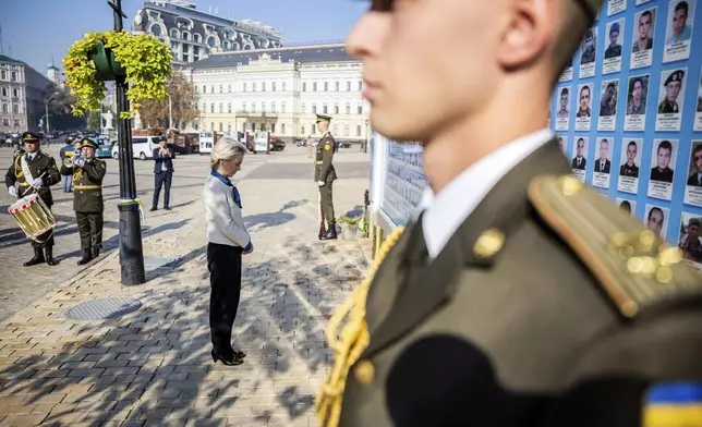 President of the European Commission Ursula von der Leyen, center, visits a wall commemorating the fallen Ukrainian soldiers in the war with Russia, in Kyiv, Ukraine, Friday, Sept. 20, 2024. (Christoph Soeder, Pool via AP)