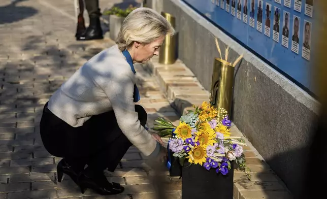 President of the European Commission Ursula von der Leyen places a bouquet of flowers at a wall commemorating the fallen Ukrainian soldiers in the war with Russia, in Kyiv, Ukraine, Friday, Sept. 20, 2024. (Christoph Soeder, Pool via AP)