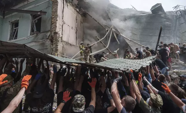 FILE - Rescuers work together to clear debris during a search operation for survivors at the Okhmatdyt children's hospital that was hit by a Russian missile, in Kyiv, Ukraine, July 8, 2024. (AP Photo/Evgeniy Maloletka, File)