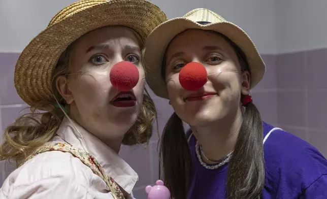 Vladyslava Kulinich, right, Tetiana Nosova, who have the clown names Lala and Zhuzha, pose for a photo as they prepare to perform at Okhmatdyt children's hospital in Kyiv, Ukraine, Thursday Sept. 19, 2024. (AP Photo/Anton Shtuka)