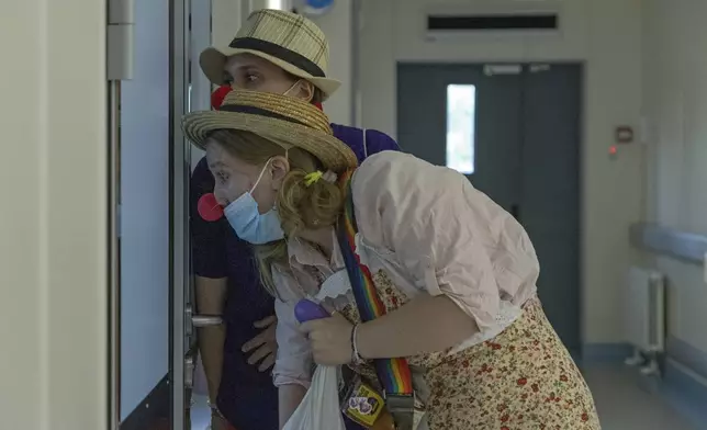 Vladyslava Kulinich, rear, and Tetiana Nosova, who have the clown names Lala and Zhuzha, prepare to perform at Okhmatdyt children's hospital in Kyiv, Ukraine, Thursday Sept. 19, 2024. (AP Photo/Anton Shtuka)