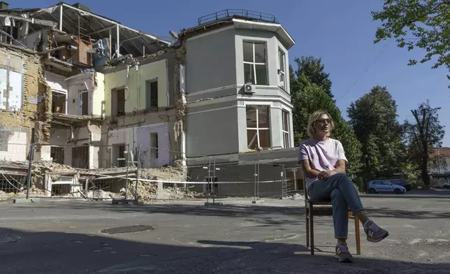 Olha Bulkina, 35, co-founder of the "Bureau of Smiles and Support" sits in front of Okhmatdyt children's hospital in Kyiv, Ukraine Saturday Sept. 14, 2024 which was destroyed after a Russian missile strike on July 8. (AP Photo/Anton Shtuka)