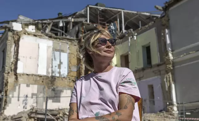 Olha Bulkina, 35, co-founder of the "Bureau of Smiles and Support" sits in front of Okhmatdyt children's hospital in Kyiv, Ukraine Saturday Sept. 14, 2024 which was destroyed after a Russian missile strike on July 8. (AP Photo/Anton Shtuka)