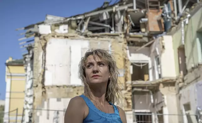 Maryna Berdar, 39, co-founder of the "Bureau of Smiles and Support" sits in front of Okhmatdyt children's hospital in Kyiv, Ukraine Saturday Sept. 14, 2024 which was destroyed after a Russian missile strike on July 8. (AP Photo/Anton Shtuka)