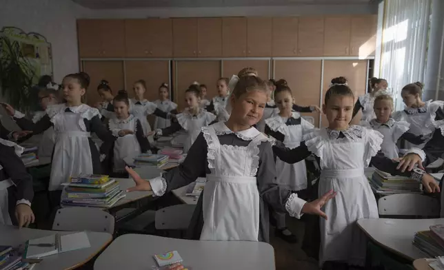 Schoolgirls attend the first lesson in a cadet lyceum on the first day at school in Kyiv, Ukraine, Monday, Sept. 2, 2024. Children and students went to school despite the fact that Kyiv was hit by massive Russian missile barrage early in the morning, causing fires, damaged buildings and infrastructure objects. (AP Photo/Efrem Lukatsky)