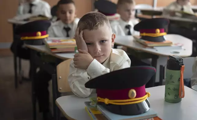 Young cadets attend the first lesson in a cadet lyceum on the first day at school in Kyiv, Ukraine, Monday, Sept. 2, 2024. Children and students went to school despite the fact that Kyiv was hit by massive Russian missile barrage early in the morning, causing fires, damaged buildings and infrastructure objects. (AP Photo/Efrem Lukatsky)