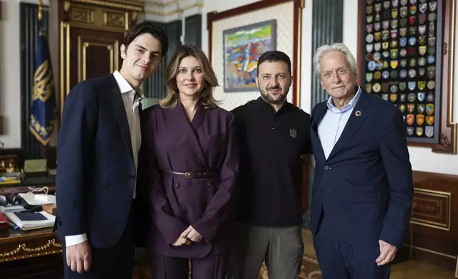 In this photo provided by the Ukrainian Presidential Press Office, Ukrainian President Volodymyr Zelenskyy and his wife Olena, center, pose for photo with US actor and UN ambassador Michael Douglas, right, and his son Dylan, left, in Kyiv, Ukraine, Friday, Sept. 13, 2024. (Ukrainian Presidential Press Office via AP)