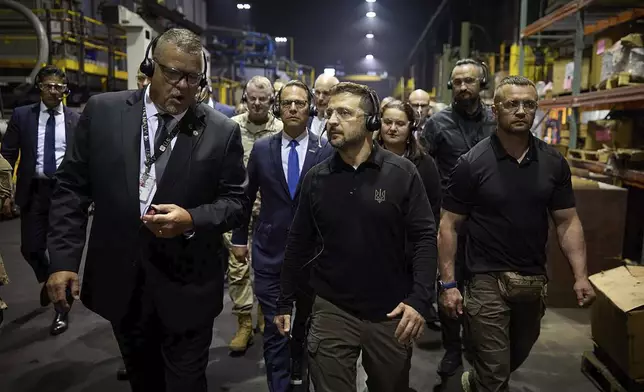 In this image provided by the Office of the Ukrainian Presidency, Ukrainian President Volodymyr Zelenskyy, left, listens to Rich Hansen, the commander's representative for the Scranton Army Ammunition Plant, in Scranton, Pa., Sunday, Sept. 22, 2024. (Office of the Ukrainian Presidency via AP)