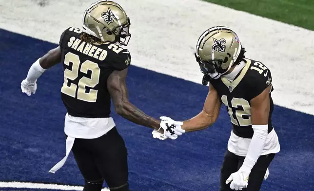 New Orleans Saints wide receiver Rashid Shaheed (22) and wide receiver Chris Olave (12) react after Olave made a catch against the Dallas Cowboys during the first half of an NFL football game, Sunday, Sept. 15, 2024, in Arlington, Texas. (AP Photo/Jerome Miron)