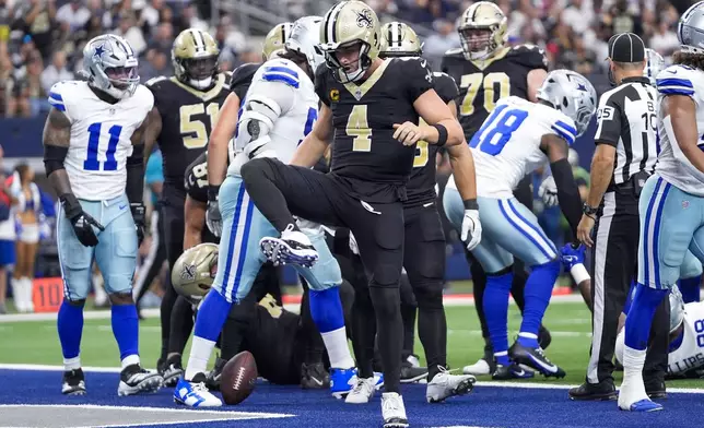 New Orleans Saints quarterback Derek Carr reacts after scoring on a keeper against the Dallas Cowboys during the first half of an NFL football game, Sunday, Sept. 15, 2024, in Arlington, Texas. (AP Photo/Tony Gutierrez)