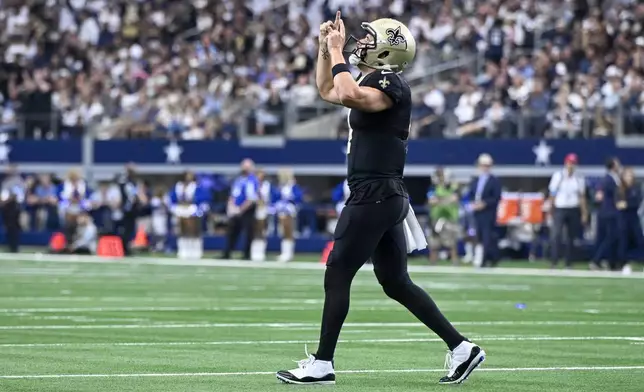 New Orleans Saints quarterback Derek Carr reacts after teammate Alvin Kamara scored a touchdown against the Dallas Cowboys during the second half of an NFL football game, Sunday, Sept. 15, 2024, in Arlington, Texas. (AP Photo/Jerome Miron)