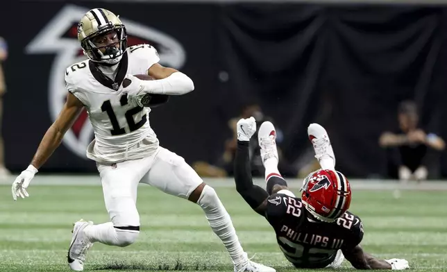 New Orleans Saints wide receiver Chris Olave (12) makes the catch against Atlanta Falcons cornerback Clark Phillips III (22) during the second half of an NFL football game, Sunday, Sept. 29, 2024, in Atlanta. (AP Photo/Butch Dill)