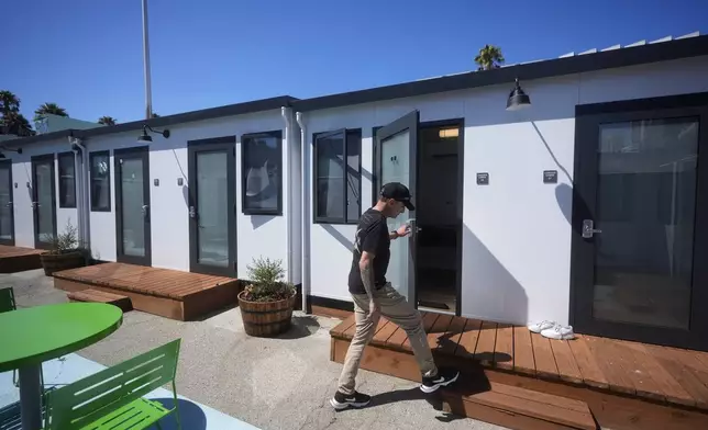 Steven Burcell walks to his room at the Five Keys' Mission Cabins transitional housing location in San Francisco, Monday, Aug. 26, 2024. (AP Photo/Jeff Chiu)