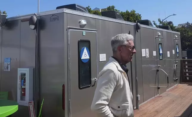 Steve Good, CEO of Five Keys, walks past restrooms at the Five Keys' Mission Cabins transitional housing location in San Francisco, Monday, Aug. 26, 2024. (AP Photo/Jeff Chiu)