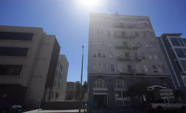 A worker cleans outside of a Five Keys transitional housing location in San Francisco, Monday, Aug. 26, 2024. (AP Photo/Jeff Chiu)