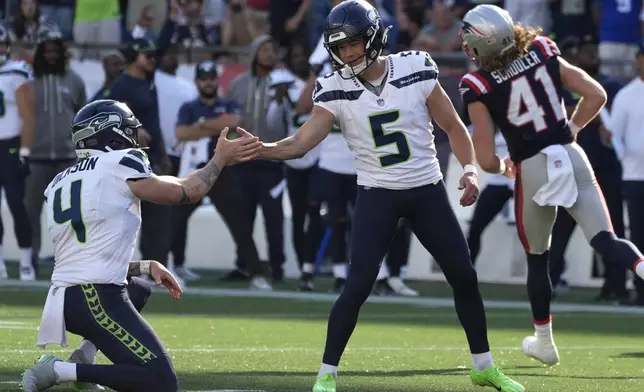 Seattle Seahawks place-kicker Jason Myers, center, celebrates with punter Michael Dickson, left, after Myers made the winning field goal in overtime of an NFL football game against the New England Patriots, Sunday, Sept. 15, 2024, in Foxborough, Mass. (AP Photo/Michael Dwyer)