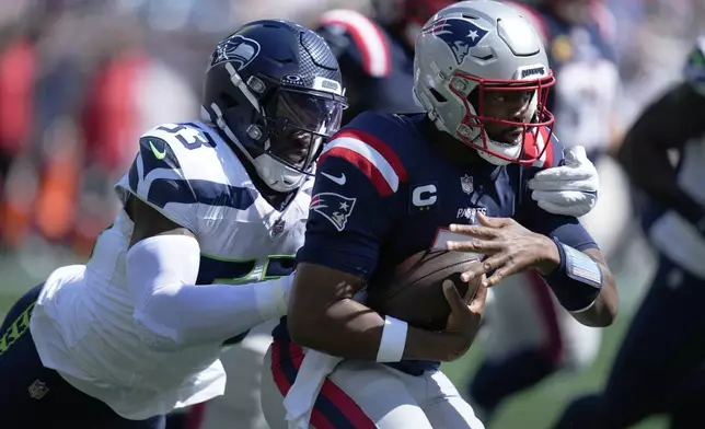 New England Patriots quarterback Jacoby Brissett, right, is brought down by Seattle Seahawks linebacker Boye Mafe, left, in the first half of an NFL football game, Sunday, Sept. 15, 2024, in Foxborough, Mass. (AP Photo/Charles Krupa)