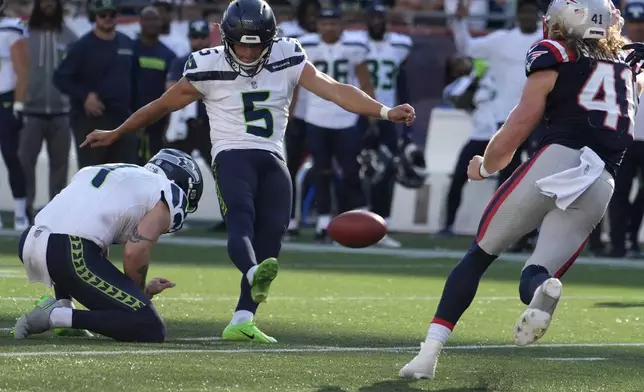 Seattle Seahawks place-kicker Jason Myers, center, boots the winning field goal in front of punter Michael Dickson, left, as New England Patriots safety Brenden Schooler, right, defends in overtime of an NFL football game, Sunday, Sept. 15, 2024, in Foxborough, Mass. (AP Photo/Michael Dwyer)