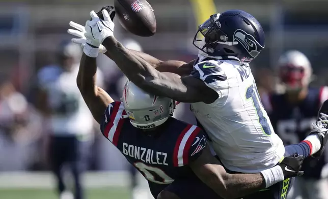 New England Patriots cornerback Christian Gonzalez, left, blocks a pass intended for Seattle Seahawks wide receiver DK Metcalf, right, in the second half of an NFL football game, Sunday, Sept. 15, 2024, in Foxborough, Mass. (AP Photo/Charles Krupa)