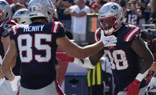 New England Patriots running back Rhamondre Stevenson, right, celebrates after his touchdown with tight end Hunter Henry, left, in the second half of an NFL football game against the Seattle Seahawks, Sunday, Sept. 15, 2024, in Foxborough, Mass. (AP Photo/Charles Krupa)